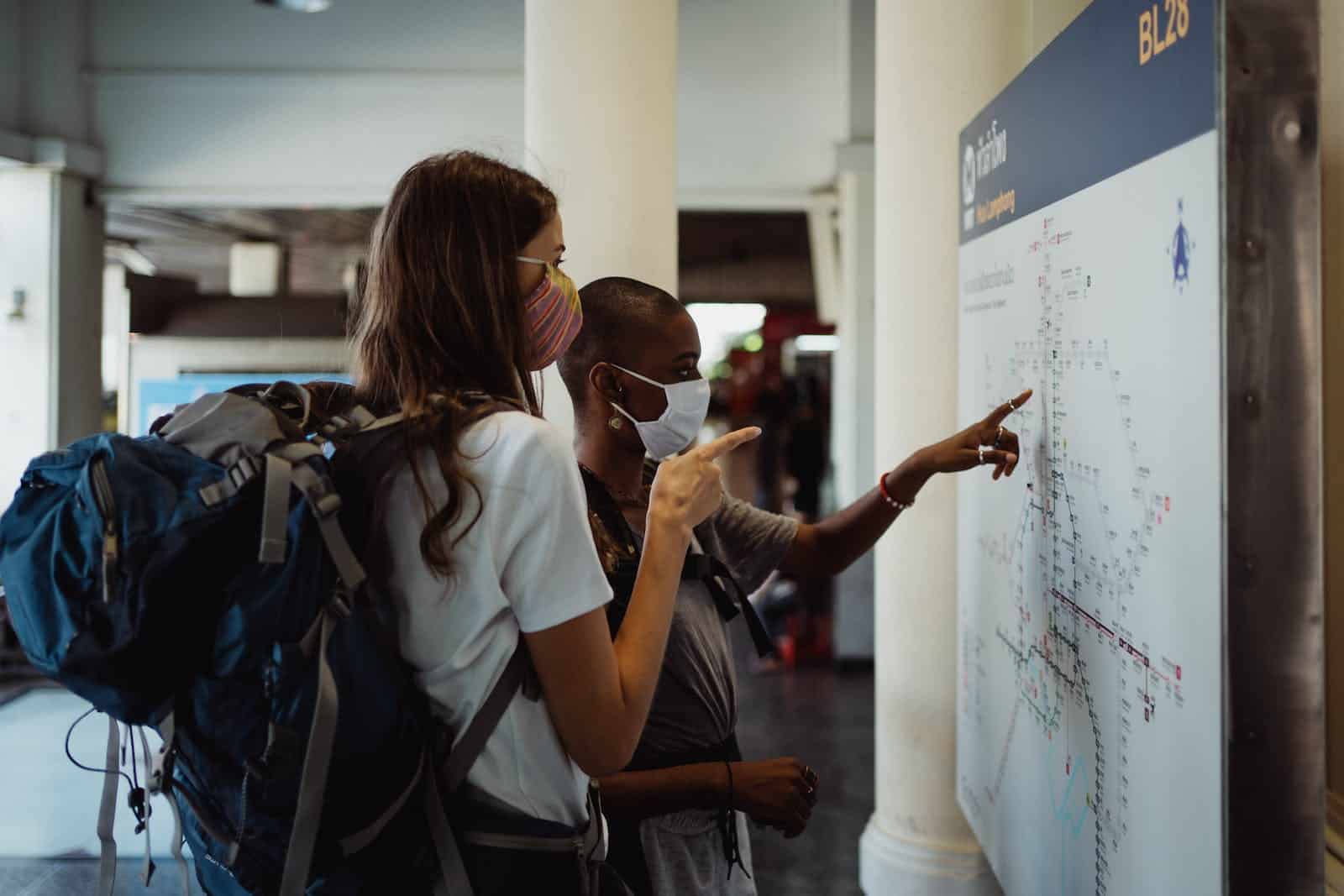 Photograph of Tourists Pointing at a Map