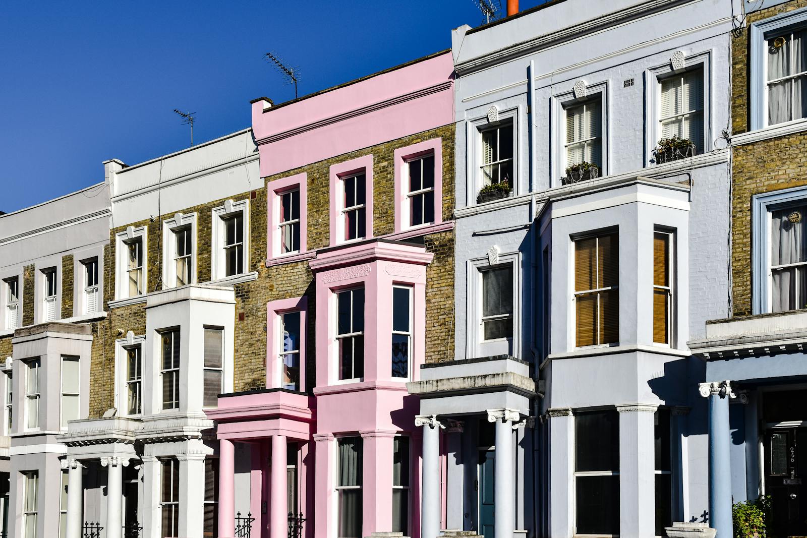 A row of houses with pink and white paint